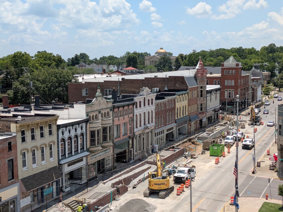 Aerial view of a downtown street under construction with historic buildings and construction equipment.